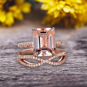 May include: A rose gold engagement ring set with a large, square-cut morganite center stone and a matching band with a delicate infinity design.