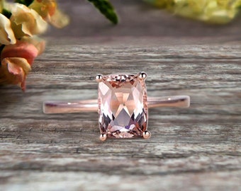 May include: A rose gold ring with a rectangular, light pink morganite gemstone.
