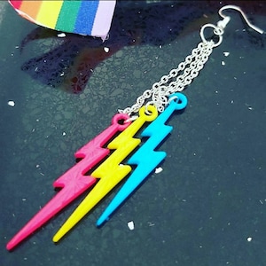 Pendientes pansexuales con los colores de la bandera del orgullo: rosa, amarillo y azul. Rayo de triple gota.