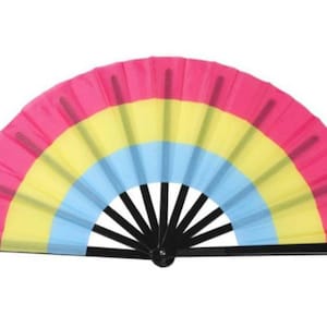 May include: A large, colorful folding fan with a black handle. The fan is made of fabric and has three stripes of pink, yellow, and blue.