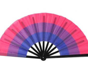 May include: A pink, purple, and blue hand fan with a black handle. The fan is made of fabric and has a layered design.