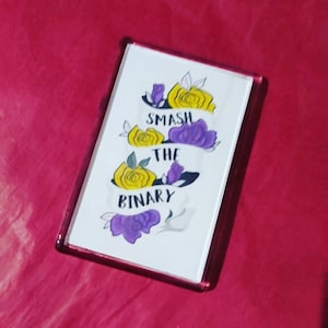 Könnte beinhalten: Ein weißer rechteckiger Magnet mit einem Design aus gelben und violetten Blumen und dem Text "Smash the Binary".