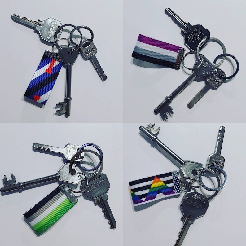 Puede incluir: Cuatro juegos de llaves con llaveros decorativos. Cada llavero presenta un dise&ntilde;o de cinta diferente con varios colores y patrones, incluyendo rayas y un arco&iacute;ris. Las llaves son de color plateado y est&aacute;n unidas a llaveros de metal.