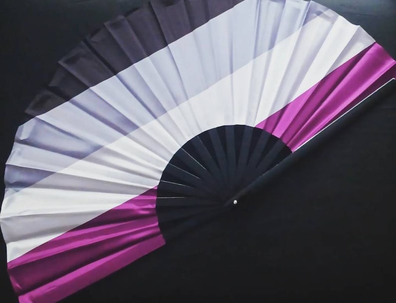 May include: A black, white, gray, and purple folding fan with a black handle.