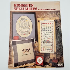 May include: A white ceramic mug with a black handle and the text "But First, Coffee" in a black, handwritten-style font. The mug is on a white surface.