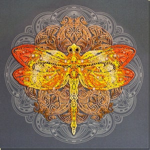May include: A close-up of a beaded dragonfly with orange, yellow, and brown accents. The dragonfly is centered on a mandala-like design with intricate details.