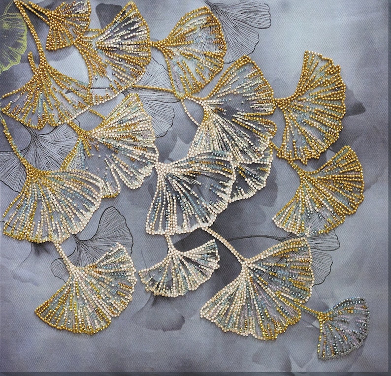May include: A close-up of a beaded embroidery design featuring a cluster of ginkgo leaves in shades of gold and silver. The leaves are arranged in a cascading pattern, creating a delicate and intricate design.