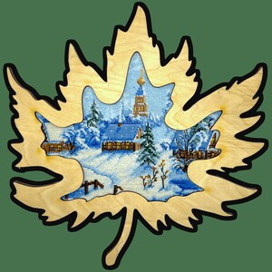 May include: A wooden maple leaf cutout with a winter village scene inside. The scene features a church, houses, and snow-covered trees.