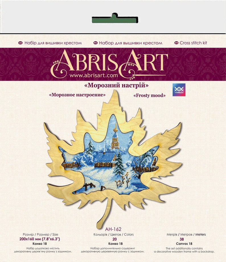 May include: Cross stitch kit featuring a winter scene with a church and houses in a snowy forest. The design is framed by a wooden maple leaf. The kit includes 20 colors, 18 count Aida fabric, and a decorative wooden frame with a backdrop. The finished size is 7.8 inches by 6.3 inches.