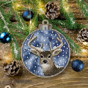 May include: A blue and white Christmas bauble with a deer inside. The bauble is round and has a white string attached to the top. The deer is brown and has antlers.