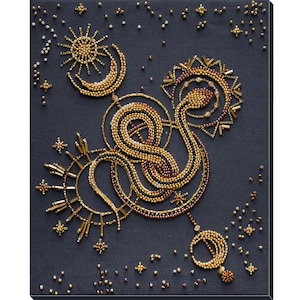 May include: A beaded artwork depicting a snake intertwined with a crescent moon and sun, all set against a dark blue background. The snake, moon, and sun are made of gold and brown beads, while the background is covered in small, silver beads.