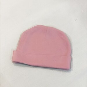 May include: A plain pink baby beanie hat.