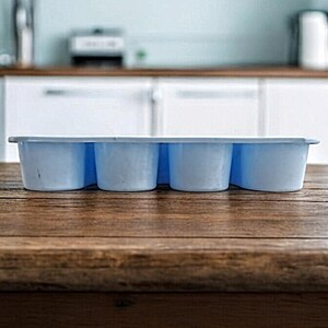 K&ouml;nnte beinhalten: Eine hellblaue Silikon-Eisw&uuml;rfelform mit sechs einzelnen F&auml;chern. Die Form steht auf einer Holzoberfl&auml;che.