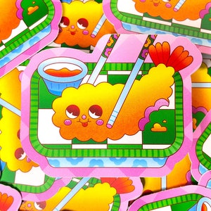K&ouml;nnte beinhalten: Ein rosa-gr&uuml;ner Aufkleber mit einer Cartoon-Garnele mit einem l&auml;chelnden Gesicht und einer Sch&uuml;ssel mit orangefarbener Sauce. Die Garnele befindet sich auf einer karierten gr&uuml;n-wei&szlig;en Oberfl&auml;che mit Essst&auml;bchen.
