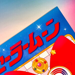 May include: A blue and red illustration of a Sailor Moon themed design with the Japanese text "セーラームーン" in red. The design features a star, a crescent moon, and a red bow.