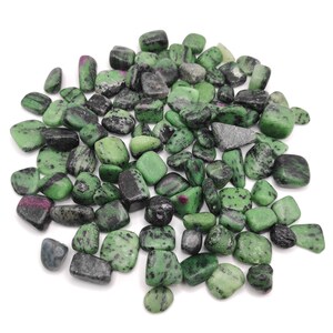 May include: A collection of tumbled zoisite stones with ruby inclusions. The stones vary in size and shape, displaying a mix of green, black, and red hues. The polished surfaces catch the light, showcasing the natural patterns and textures of the minerals.