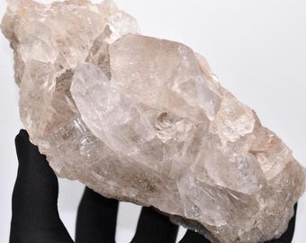 May include: A large cluster of clear quartz crystals with a milky, translucent appearance. The crystals are clustered together in a natural formation, creating a unique and beautiful display.