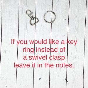 May include: A silver swivel clasp and a silver key ring on a white wooden background. The text "If you would like a key ring instead of a swivel clasp leave it in the notes." is written in red below the items.