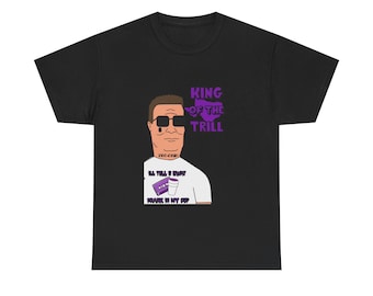 May include: Black t-shirt with a cartoon illustration of a man wearing sunglasses and a white shirt. The text "KING OF THE TRILL" is printed in purple above the illustration. The text "I'LL TELL U WHAT" and "POUR IT IN MY CUP" is printed below the illustration.