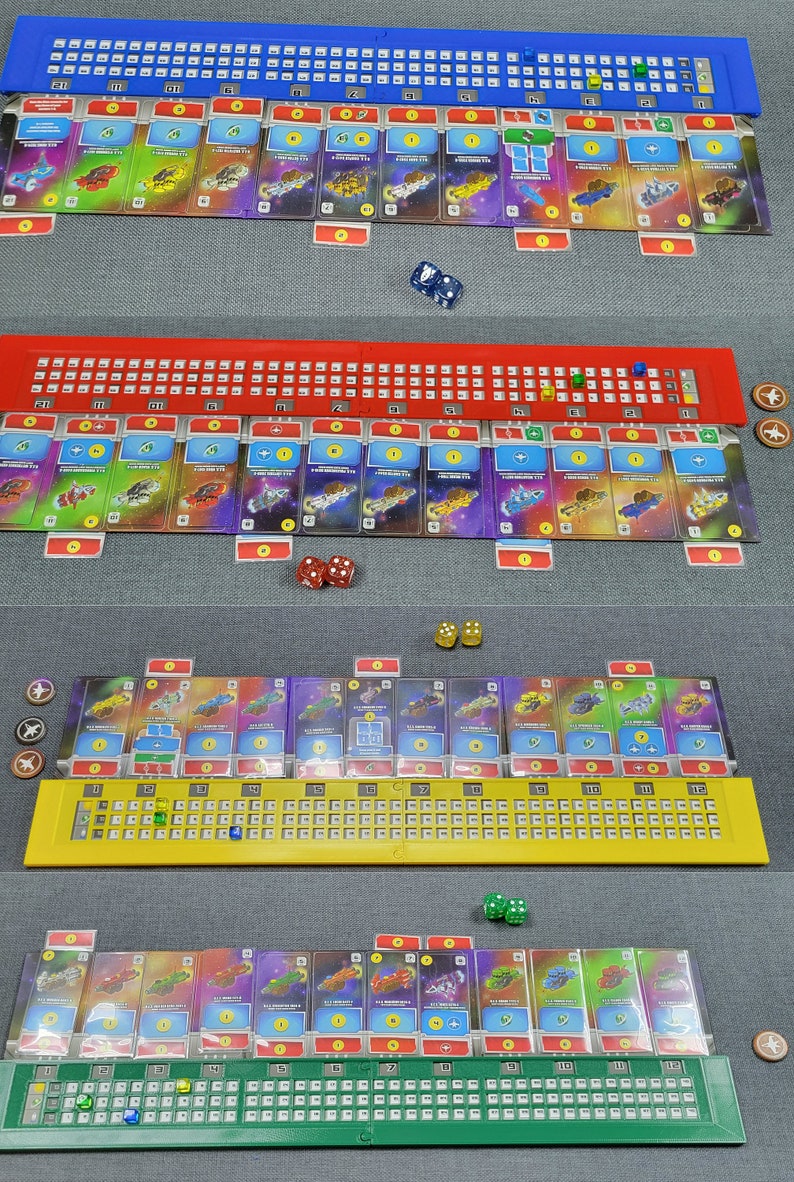 May include: A board game setup featuring four player boards in blue, red, yellow, and green. Each board has a numbered track and card slots. Dice and tokens are placed around the boards, and cards with spaceship designs are visible.