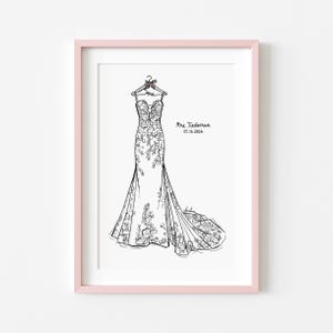 May include: A framed line art illustration of a floor-length mermaid-style gown with floral lace details hanging on a hanger labeled Mrs. The text Mrs. Tiedeman and 05.16.2026 is printed to the right of the dress in a black script font.