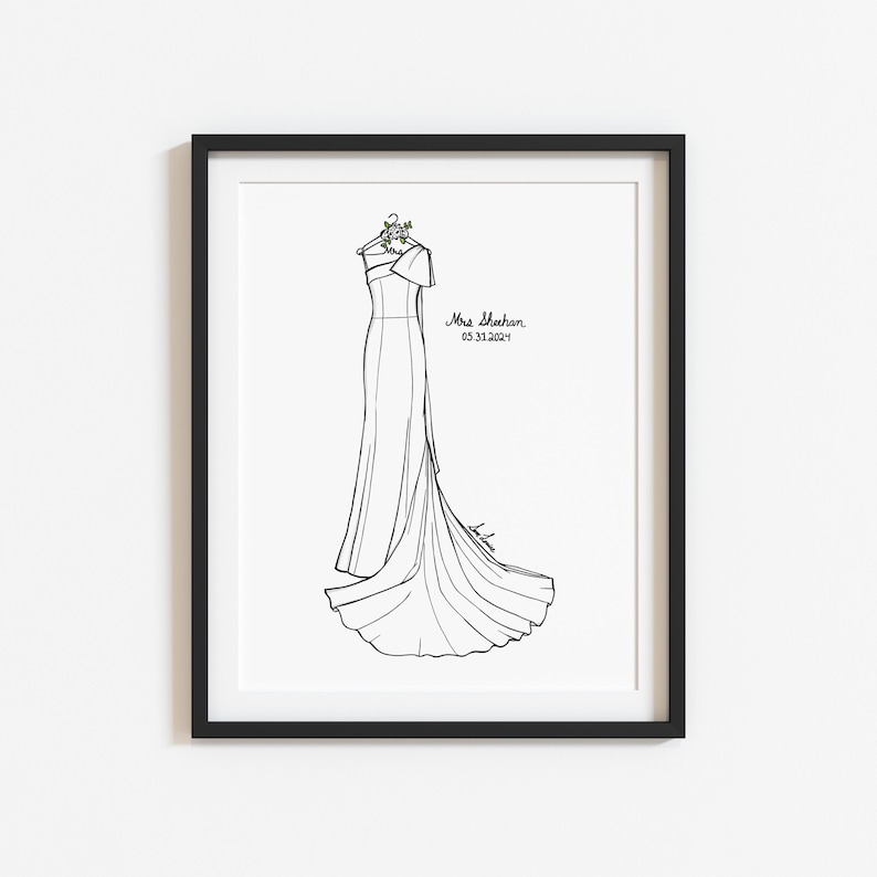 May include: A black and white line art illustration of a one-shoulder gown hanging on a hanger with a small floral detail. The text Mrs. Sheehan and 05.31.2024 are printed to the right of the dress. The artwork is displayed in a black frame.