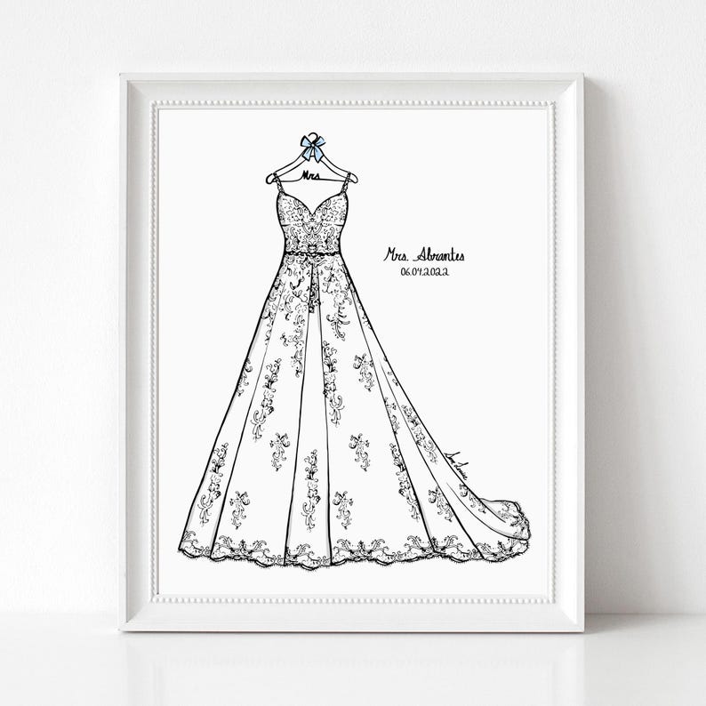 May include: A framed line art illustration of a floor-length wedding dress on a hanger with a blue bow. The hanger is labeled Mrs. The text Mrs. Abrantes and 06.04.2022 is printed to the right of the dress. The dress features intricate floral details.