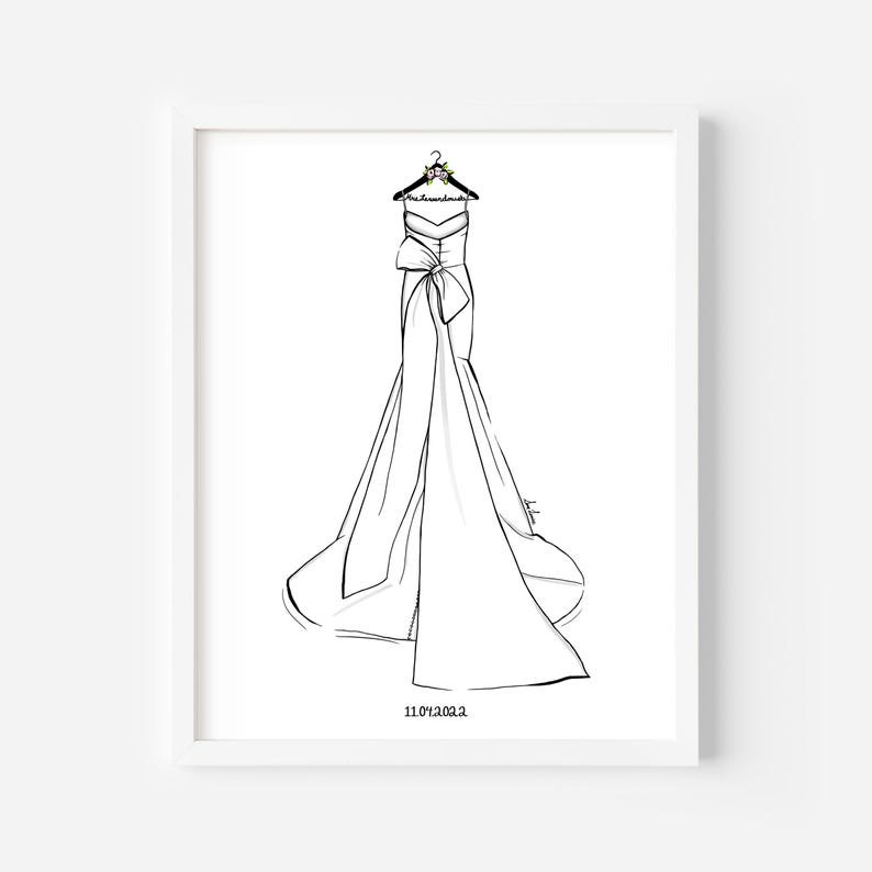 May include: A black and white line art illustration of a strapless gown with a large bow at the waist and a long train, hanging on a hanger labeled Mrs. Lewandowski. The date 11.04.2022 is printed in black text at the bottom of the framed print.