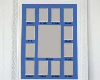 Può includere: Cornice per foto bianca con un passepartout blu e 12 aperture per foto. Ogni apertura è etichettata con un livello di grado, dalla scuola materna alla 12a elementare.
