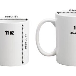 May include: Two white ceramic mugs with black text. The mug on the left is 11 ounces and the mug on the right is 15 ounces. The mugs are shown next to rulers with measurements in inches and centimeters.