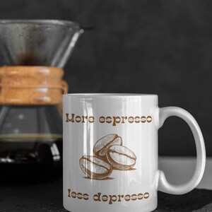 May include: White ceramic coffee mug with a brown graphic of coffee beans and the text "More espresso less depresso".