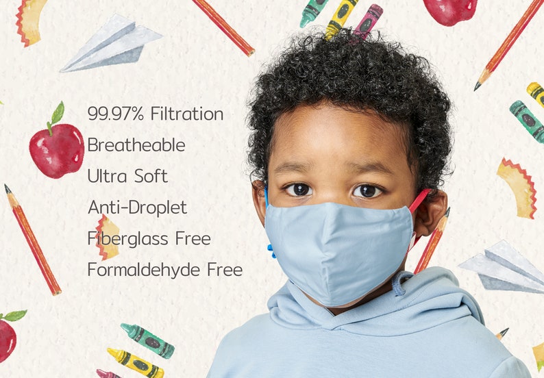 May include: A young boy wearing a light blue face mask with the text "99.97% Filtration, Breathable, Ultra Soft, Anti-Droplet, Fiberglass Free, Formaldehyde Free" on a white background with drawings of apples, pencils, and crayons.