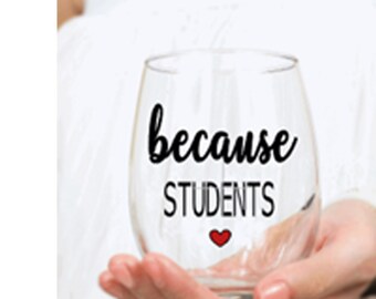 May include: A clear glass wine glass with the text "because students" and a small red heart.