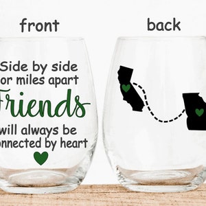 May include: Two stemless wine glasses with a friendship quote on the front and a map of California and Georgia connected by a dotted line on the back. The quote reads "Side by side or miles apart Friends will always be connected by heart".