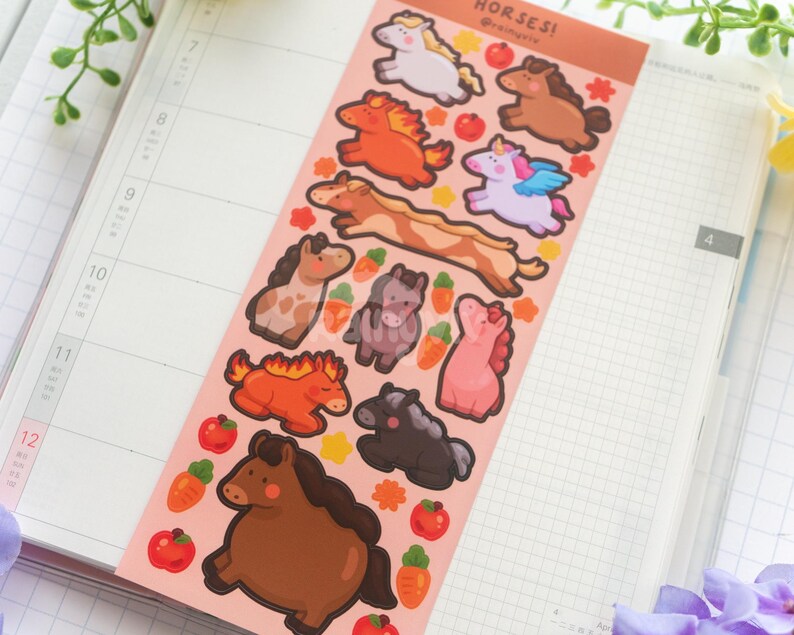 May include: A sticker sheet with cartoon horse designs in various colours and poses. The stickers include a white horse, a brown horse, an orange horse with a fiery mane, and a pink pegasus. The sheet is on a pink background with the word "HORSES!" at the top.