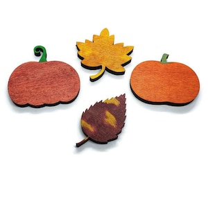 May include: Four wooden fall-themed cutouts: two pumpkins, and two leaves. The pumpkins are orange and red with green stems. One leaf is yellow, and the other is brown with yellow accents. All are on a white background.