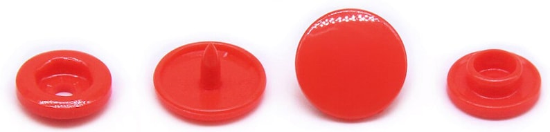 Peut inclure: Quatre boutons-pression en plastique rouge. Les boutons sont ronds et ont un dessus plat. Deux des boutons ont un centre sur&eacute;lev&eacute; et deux des boutons ont un centre plat.