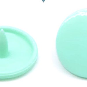 Peut inclure: Quatre boutons-pression en plastique vert menthe, deux avec un centre sur&eacute;lev&eacute; et deux avec un centre encastr&eacute;.