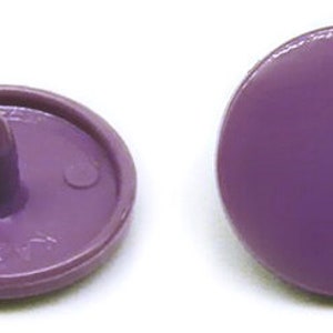 Peut inclure: Quatre boutons-pression en plastique violet, deux avec un centre sur&eacute;lev&eacute; et deux avec un dessus plat.