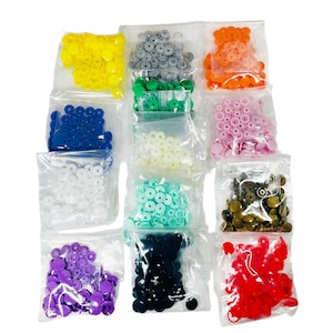 Peut inclure: Assortiment de boutons-pression en plastique de diff&eacute;rentes couleurs, notamment rouge, orange, jaune, vert, bleu, violet, blanc, noir, gris et or. Les boutons sont emball&eacute;s dans des sachets en plastique transparent individuels.