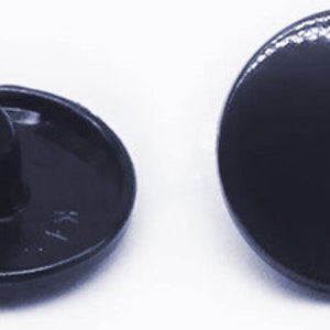 Peut inclure: Quatre boutons en plastique noir avec un centre sur&eacute;lev&eacute;. Deux boutons ont un dessus plat et deux boutons ont un centre sur&eacute;lev&eacute;.