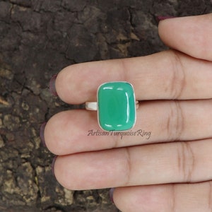 以下が含まれることがあります： 長方形の緑色の宝石がついた銀の指輪。指輪はシンプルなバンドにセットされており、石は滑らかで磨かれています。Artisan Turquoise Ring.