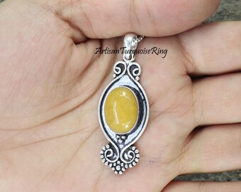 May include: A silver pendant with an oval-shaped yellow gemstone set in a filigree design. The pendant is on a silver chain.