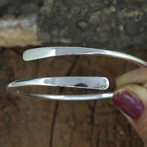 Puede incluir: Un brazalete de plata abierto, de envoltura. El brazalete est&aacute; hecho de una sola pieza de metal que se dobla en un c&iacute;rculo y luego se tuerce para crear un efecto espiral. El brazalete es simple y elegante, y ser&iacute;a un gran regalo para cualquier ocasi&oacute;n.