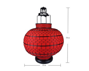 May include: A red Chinese lantern with a black wire frame, standing on a black base. The lantern is 50 cm tall and 35 cm wide.