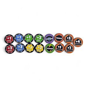 May include: A selection of circular game tokens with black borders and various symbols and numbers. The tokens display text such as "ATK", "DEF", and "THW", alongside numbers like +1, +2, +3, and +4. Some tokens have special effects, including "CONFUSED" and "STUNNED".