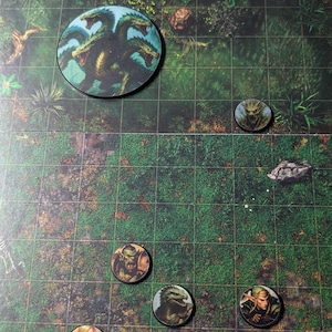 K&ouml;nnte beinhalten: Eine Tisch-Rollenspielkarte mit mehreren kreisf&ouml;rmigen Charaktermarken. Die Marken zeigen Illustrationen von Fantasy-Kreaturen und -Charakteren, darunter eine Hydra, ein Ork und ein Elf. Die Karte hat ein Rastermuster und einen waldartigen Hintergrund.