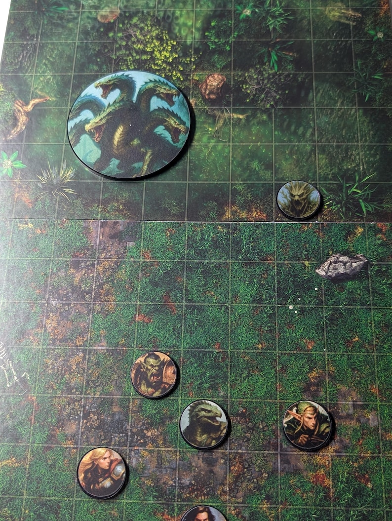 K&ouml;nnte beinhalten: Eine Tisch-Rollenspielkarte mit mehreren kreisf&ouml;rmigen Charaktermarken. Die Marken zeigen Illustrationen von Fantasy-Kreaturen und -Charakteren, darunter eine Hydra, ein Ork und ein Elf. Die Karte hat ein Rastermuster und einen waldartigen Hintergrund.