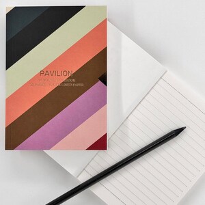 Può includere: Un taccuino con copertina rigida con un motivo a righe diagonali nei toni del nero, verde, arancione, marrone, viola e rosso. La copertina recita "PAVILION" e "A BOUND NOTEBOOK 96 PAGES - 80GSM LINED PAPER". Una matita nera è appoggiata sulle pagine a righe aperte.