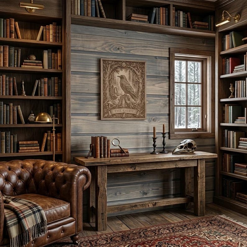 May include: A wooden study featuring a brown leather tufted armchair with a plaid throw, a rustic wooden console table, and floor-to-ceiling bookshelves. A framed print titled THE RAVEN hangs on the wall above the table, alongside a bird skull.